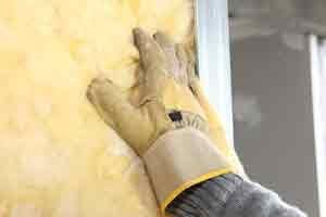 a gloved hand installing insulation Chicago IL